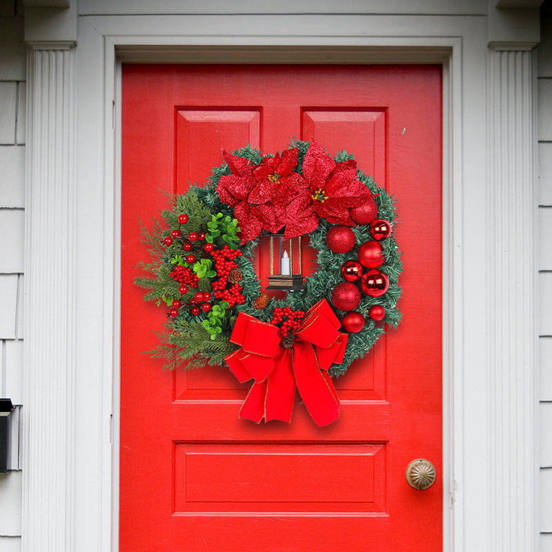 Christmas wreath with decorative lantern and red flowers