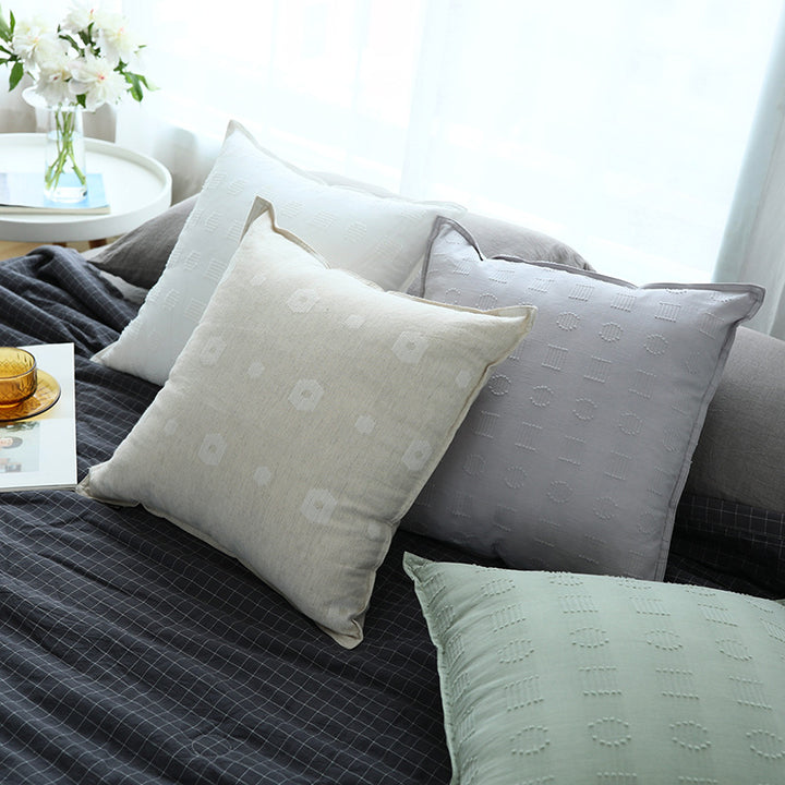 Square decorative cushion cover with subtle tufted geometric relief and piping
