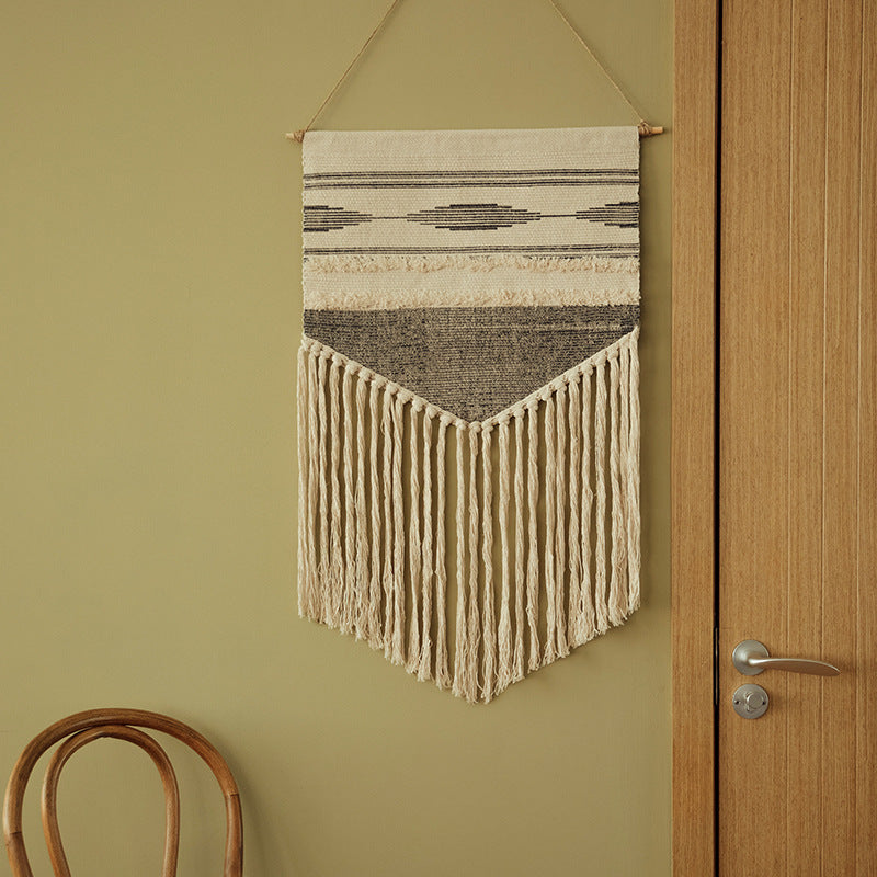 Woven wall hanging in Aztec style with cotton fringes and wooden rod