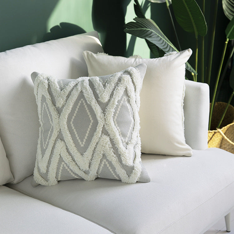 Decorative cushion cover with hand-tufted diamond relief and soft bouclé application