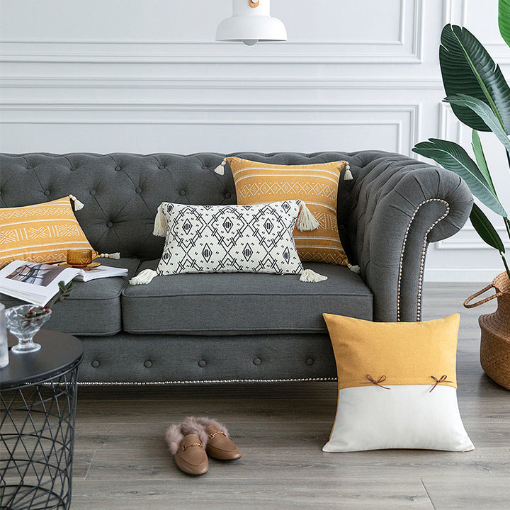 Square decorative cushion cover made of cotton blend with handwoven texture, geometric diamond print, and corner tassels