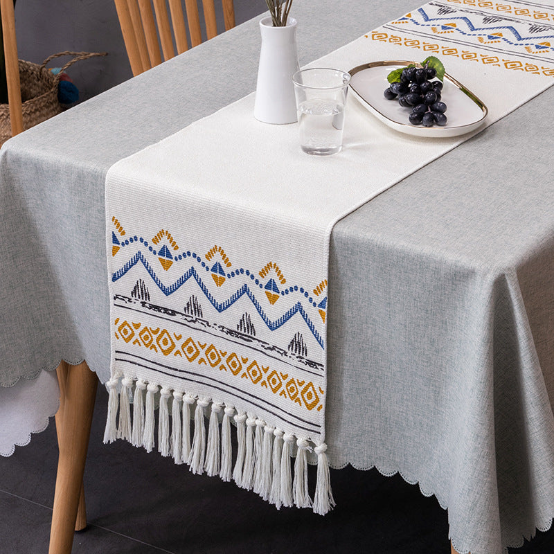 Woven table runner with fringes and ethnic chevron pattern