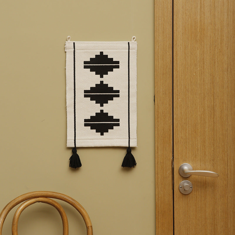 Woven wall hanging in minimalist geo pattern with decorative tassels and hanging loops