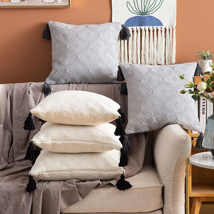 Decorative cushion cover made of woven cotton blend with tactile diamond structure and contrast tassels