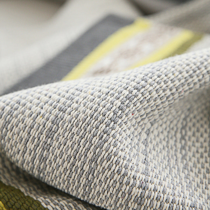 Handwoven table runner made of cotton blend with woven decorative border and striped texture