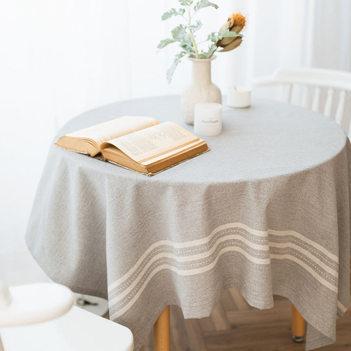 Rectangular tablecloth made of cotton-linen blend with subtle striped border and decorative tassels