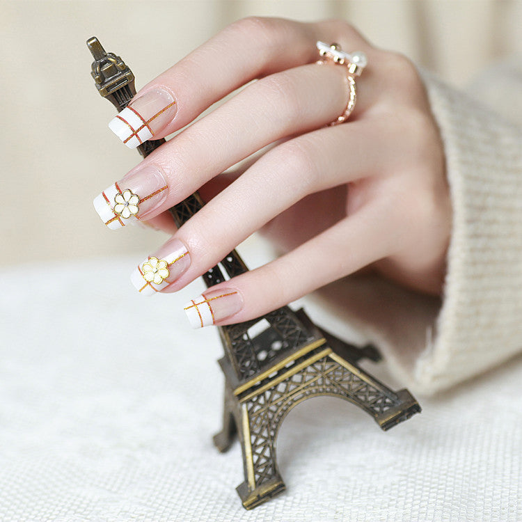 Artificial nails with elegant 3D flower accents and gold trim Stornfield