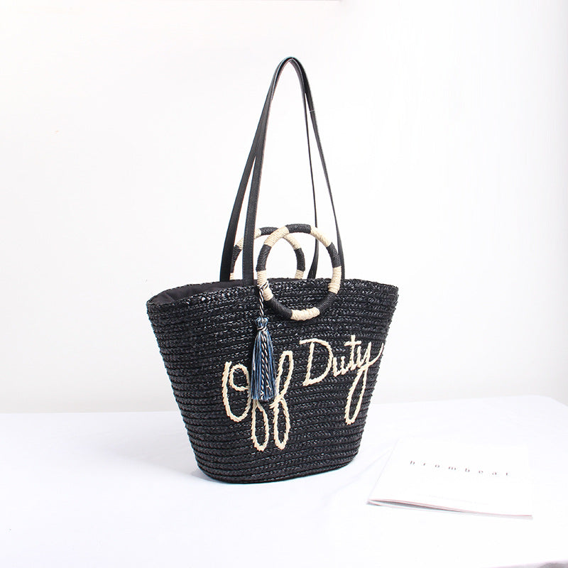 Designer shoulder bag with playful lettering and decorative tassel detail Stornfield