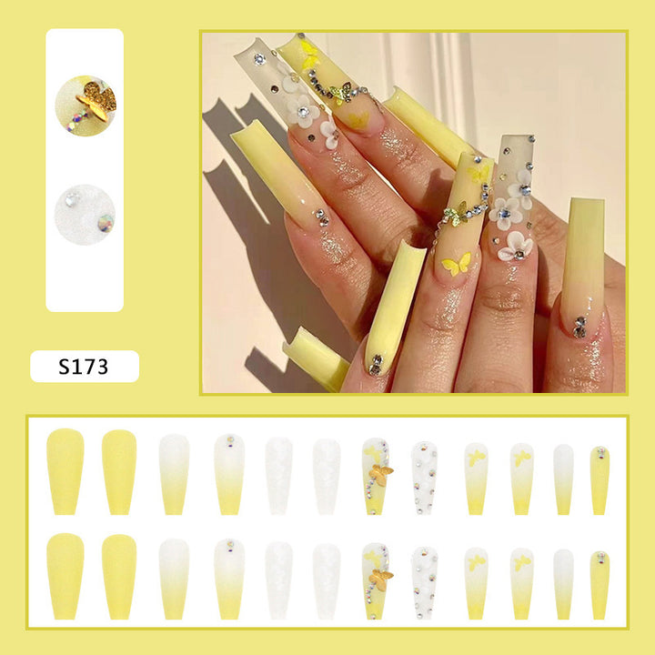 Artificial nail extensions with floral accents and rhinestones Stornfield