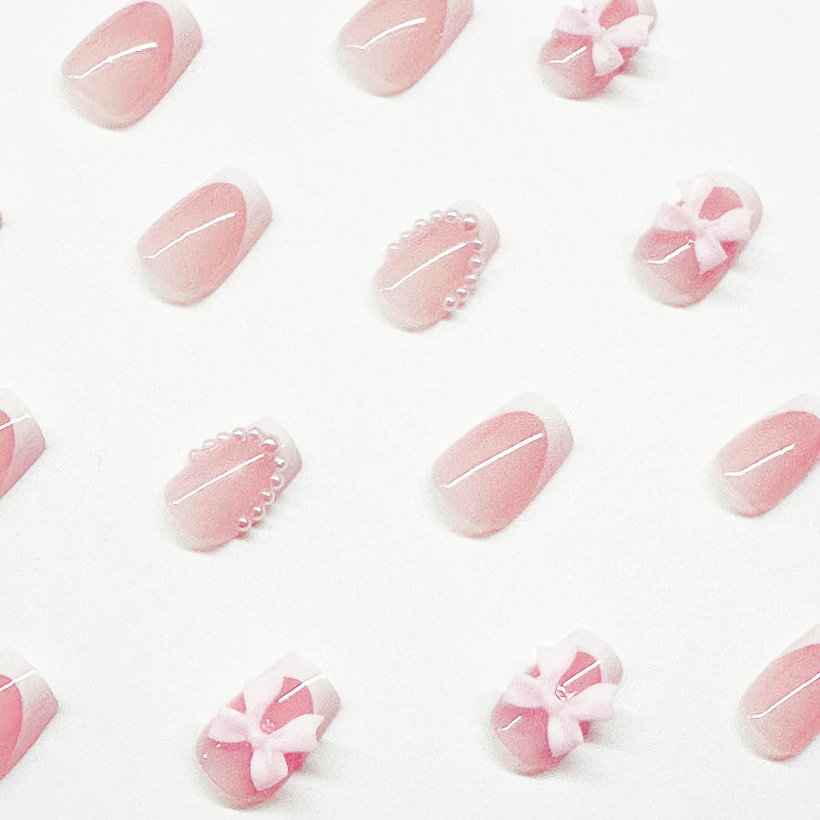 Artificial nails with elegant bows and pearl embellishments Stornfield