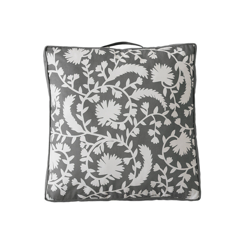 Padded floor cushion with quilted tufting, floral motif and carrying handle