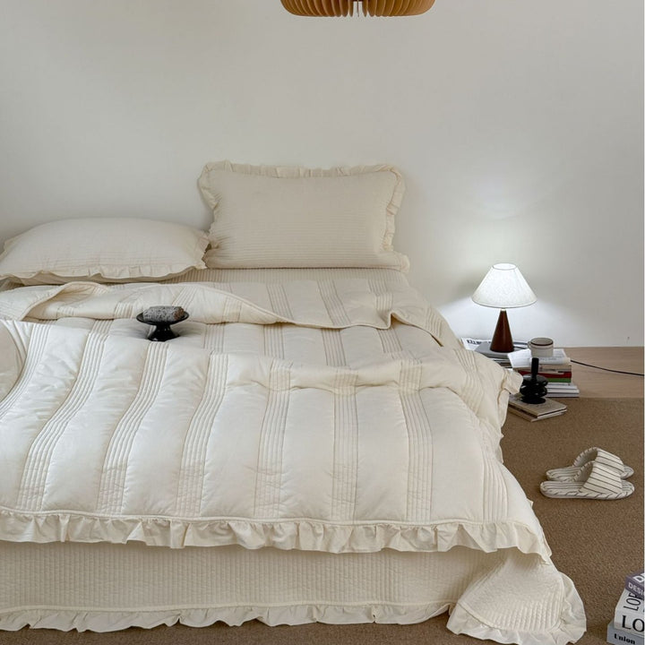 Padded quilted bedding set with ruffled trim and fine channel stitching