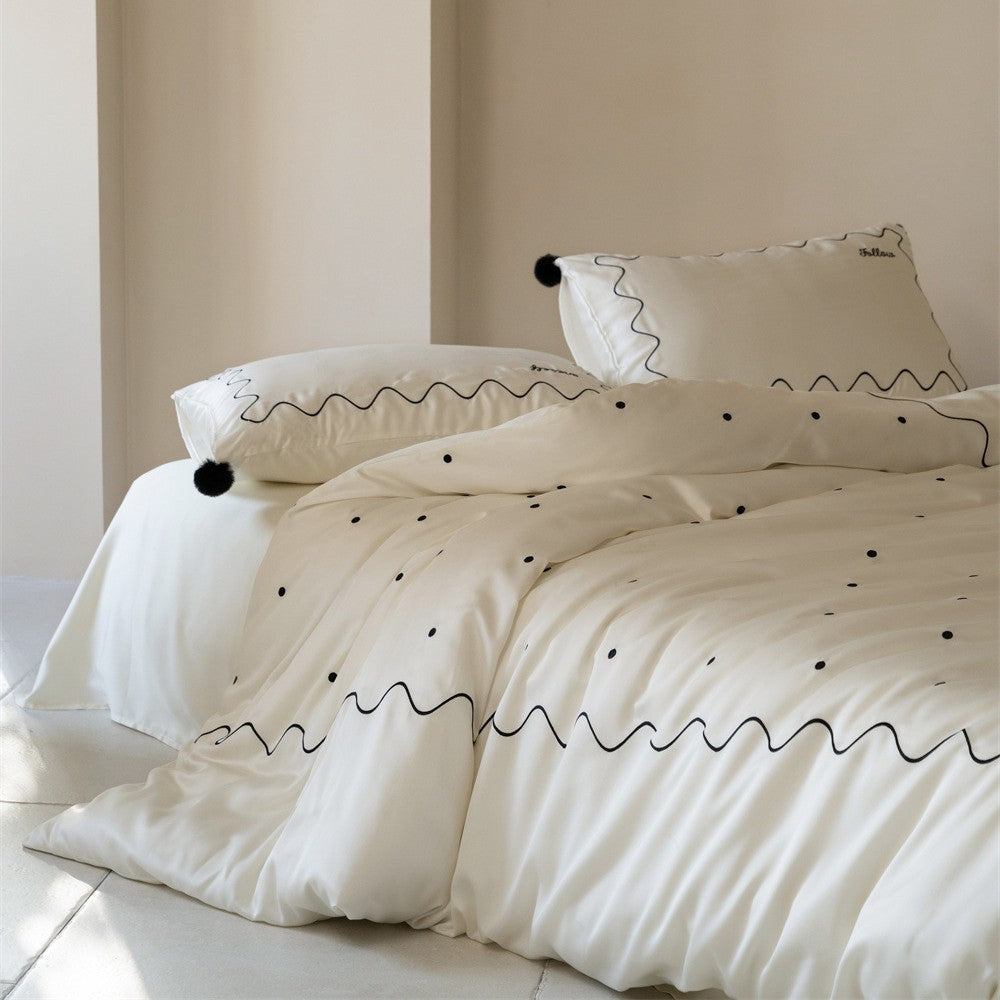 Bedding set made of cotton satin with wavy embroidery edge and pompom cushion