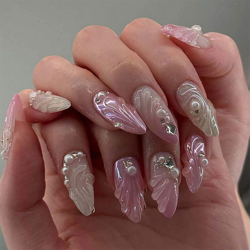 Artificial nail art with elegant swirl design and pearl embellishments Stornfield