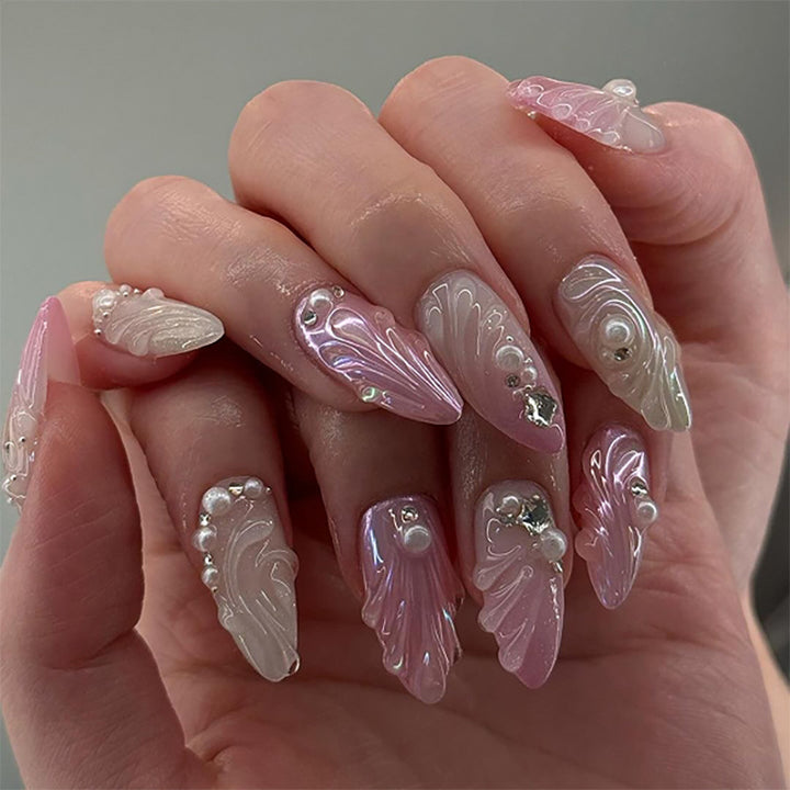 Artificial nail art with elegant swirl design and pearl embellishments Stornfield