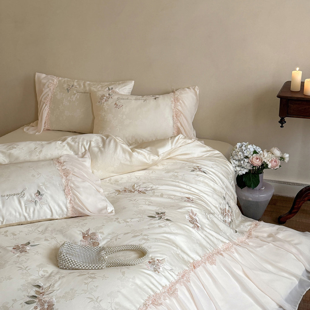 Romantic satin bedding set with embroidered floral design, ruffle and pillowcases