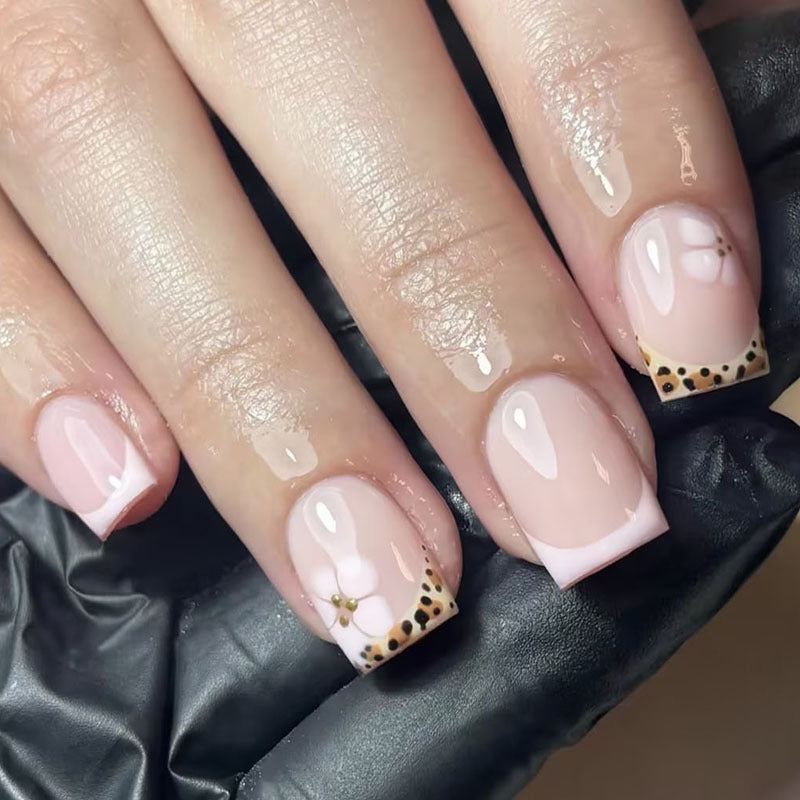 Artificial nail set with elegant French tip and floral accent Stornfield