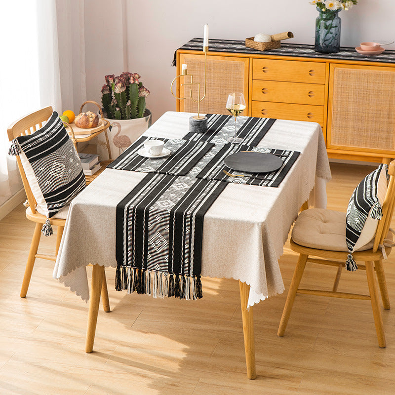 Handwoven table runner made of cotton blend with geometric weave pattern and fringe trim