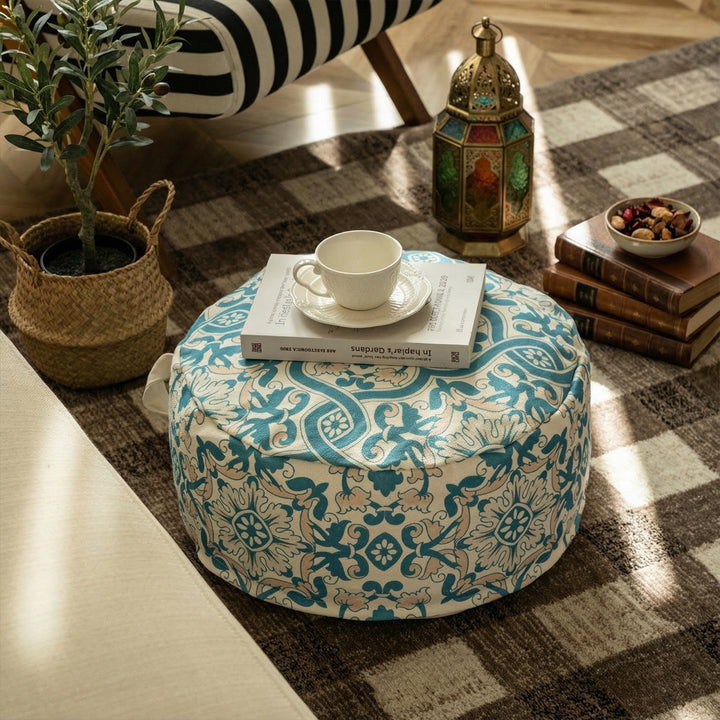 Round floor pouf with woven ornament pattern and carrying handle Stornfield