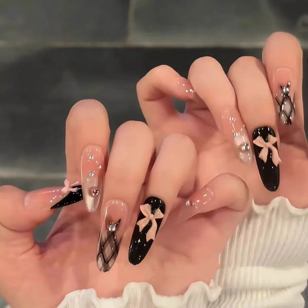 Artificial nails with playful bow and glitter accents Stornfield