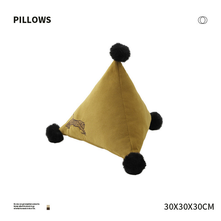 Pyramid-shaped triangle cushion with faux fur pom-poms and zebra embroidery