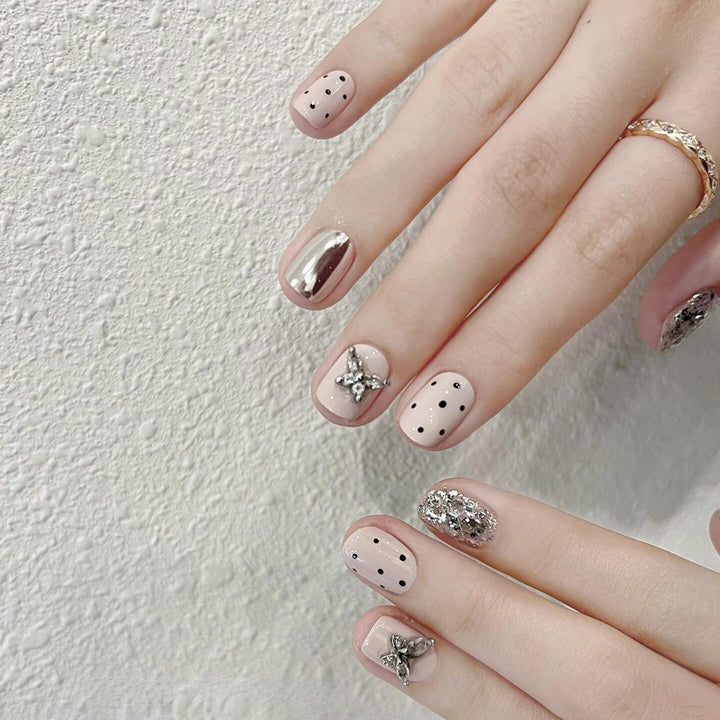 Artificial nails with playful design and glitter accents Stornfield