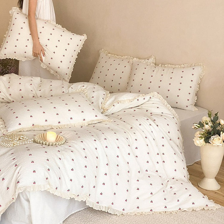 Quilted bedding set made of cotton muslin with delicate cherry print and ruffle edge