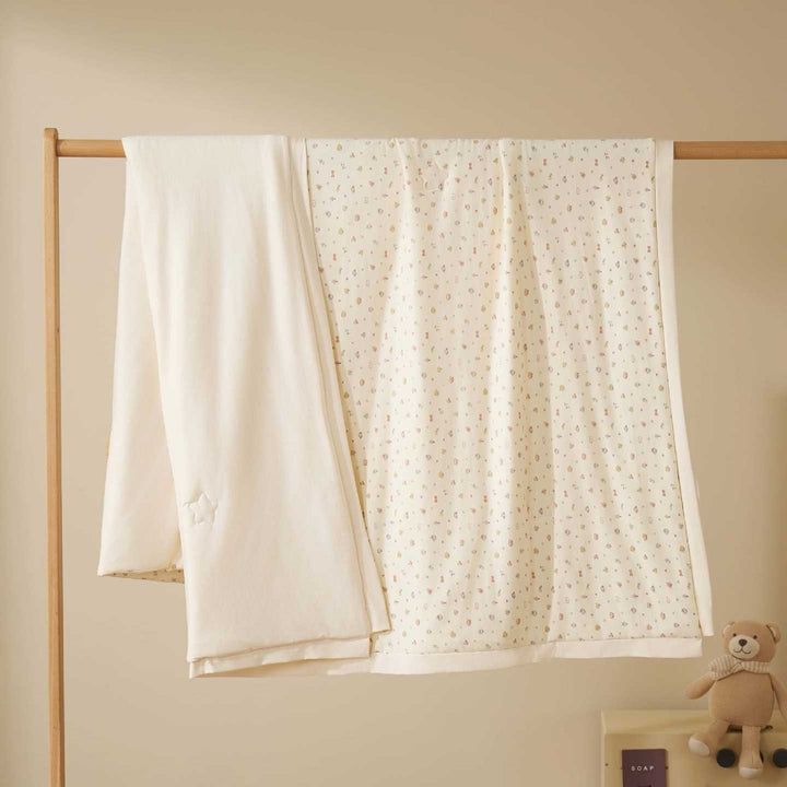Double-layer baby crawling blanket made of cotton jersey with light padding and delicate all-over animal print