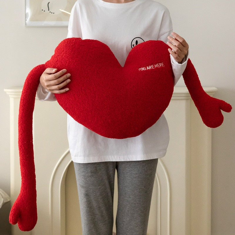 Cuddle pillow in heart shape with extra long arms made of sherpa fleece and embroidery detail