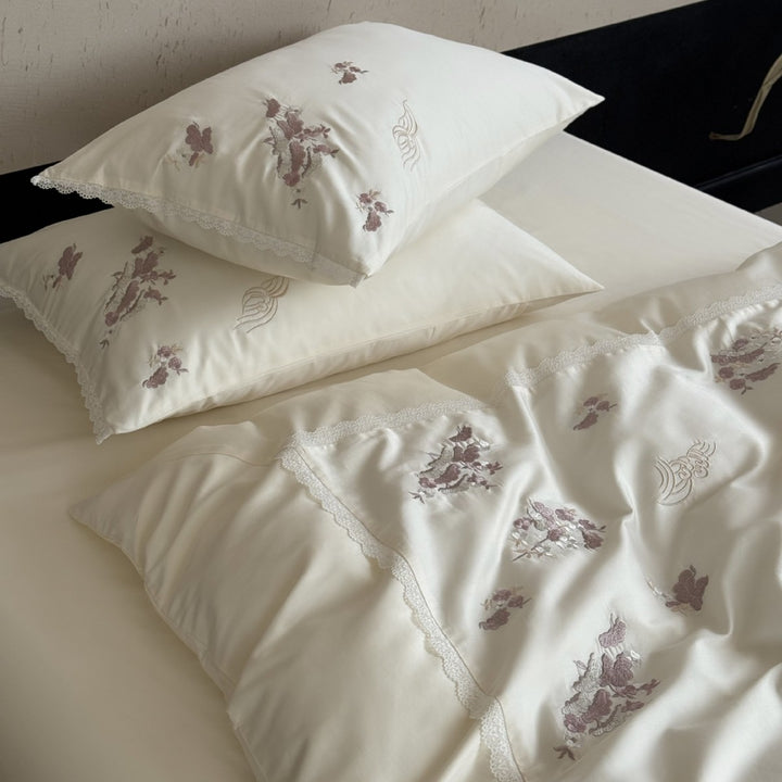Satin bedding set with subtly embroidered flowers and lace trim