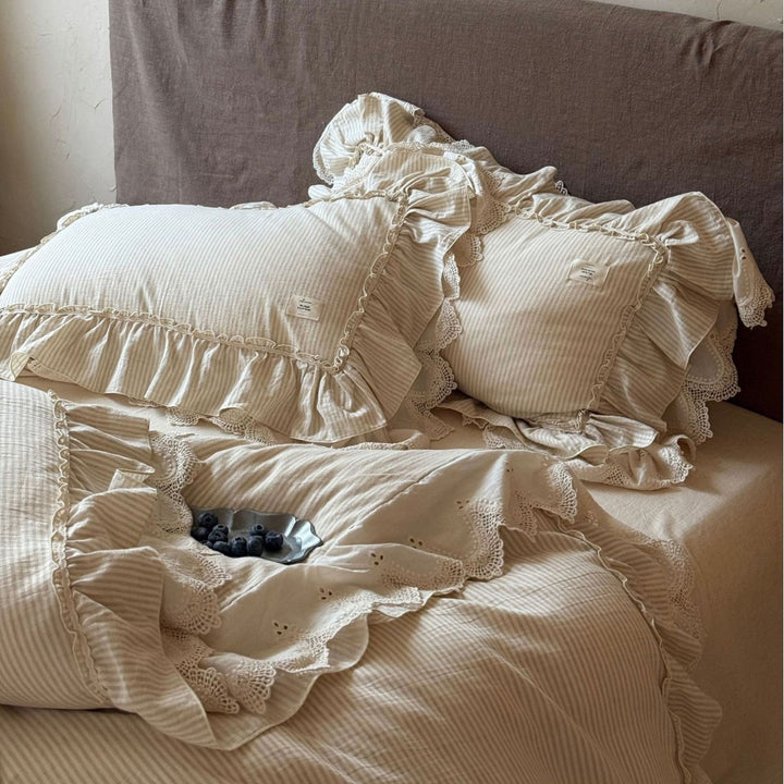 Country house style bed linen set with ruffles, lace border and quilted bedspread