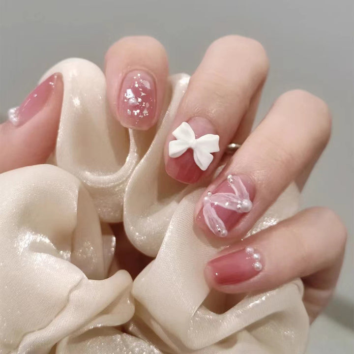 Glamorous nail art with pearl and bow accents Stornfield