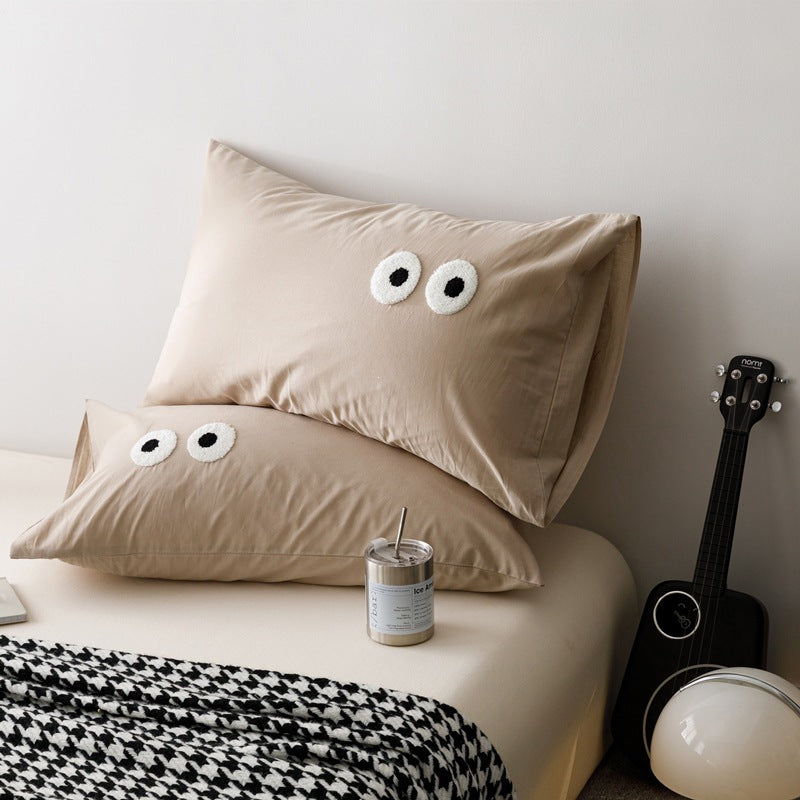 Playful cushion cover set with embroidered eye appliqués made of soft cotton fabric