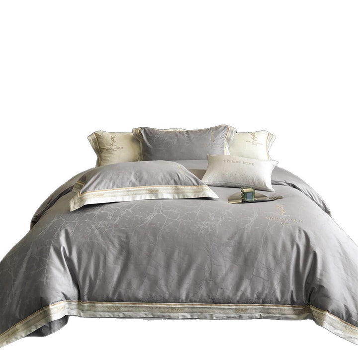 Luxurious satin bedding set with subtle marble texture and golden embroidered border