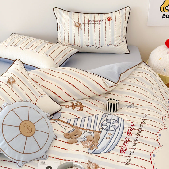 Children's bedding set with embroidered comic design and striped details