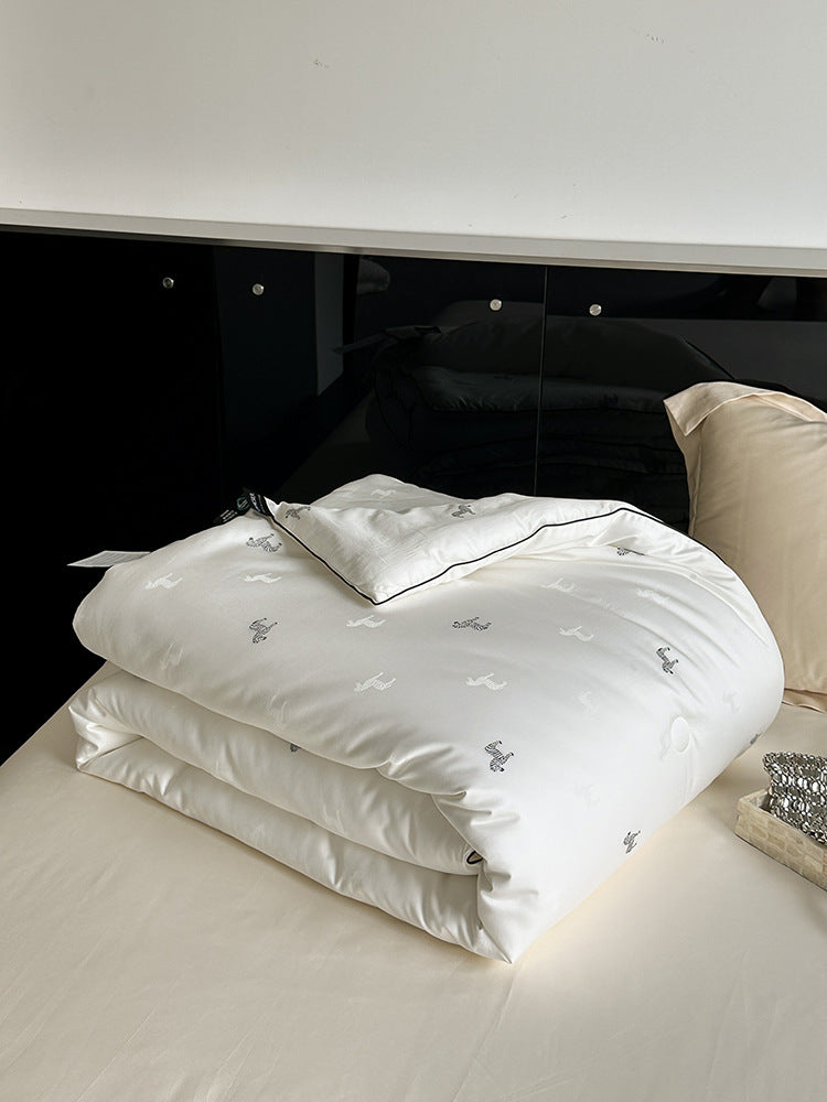 Light-warming cassette comforter with hollow fiber filling and fine tonal embroidery