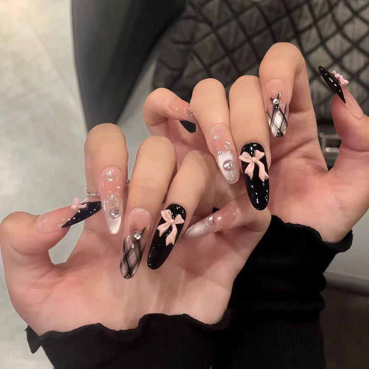 Artificial nails with playful bow design and glitter effects Stornfield