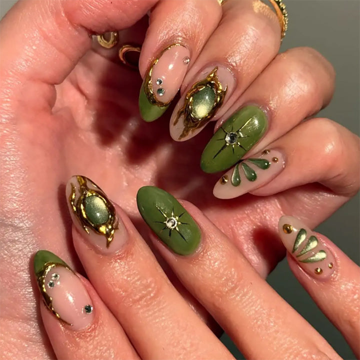 Artistic nail extensions with elegant gold and green shimmer Stornfield