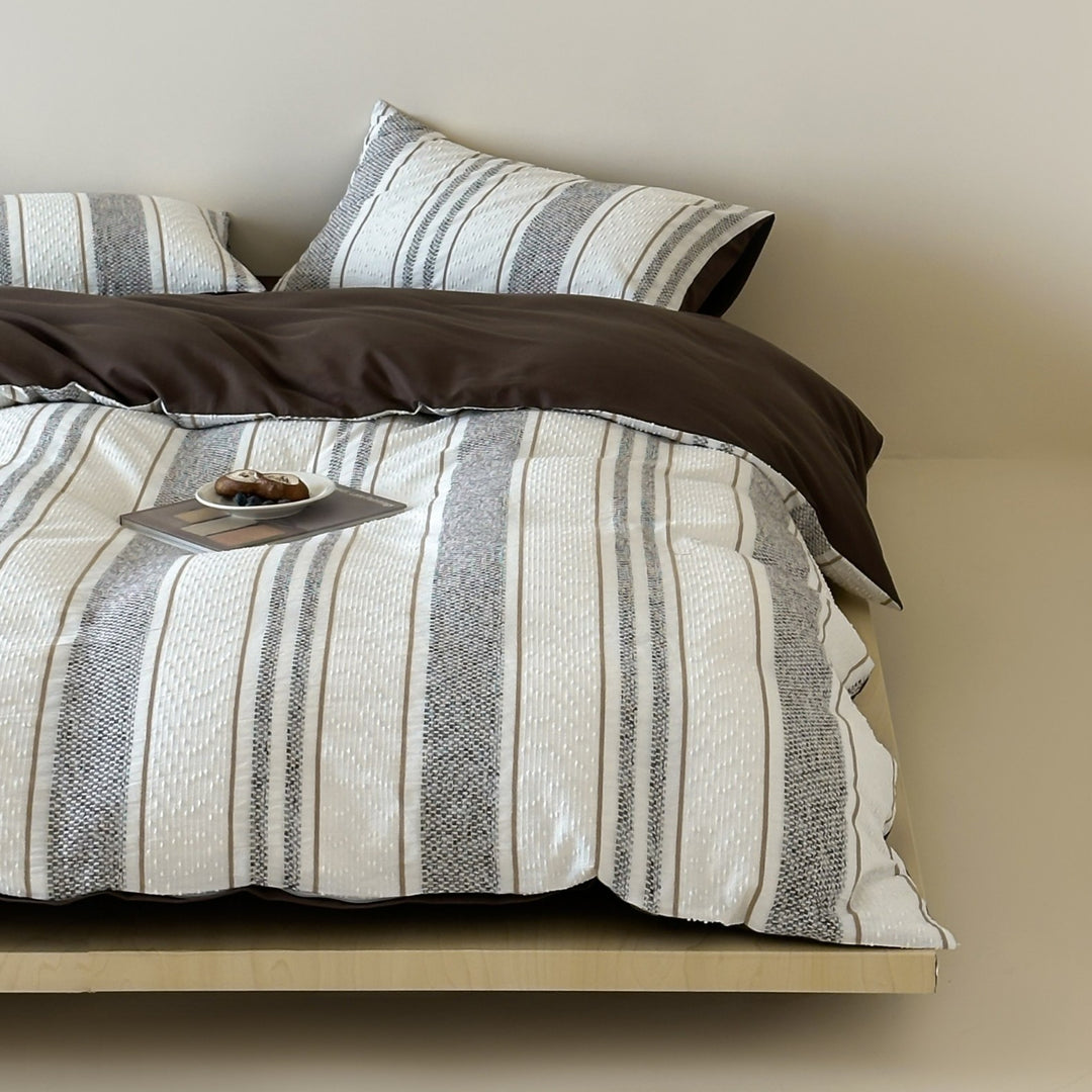 Reversible bedding set with textured striped look and fine quilting