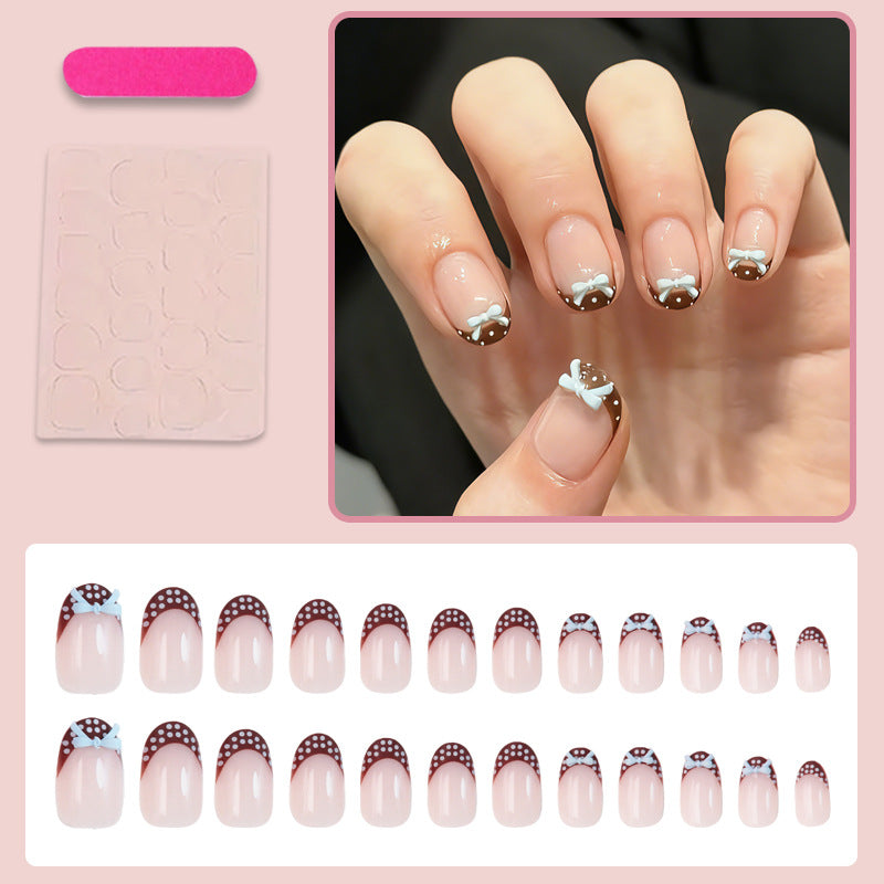 Artificial nail set with playful bows and elegant dots Stornfield