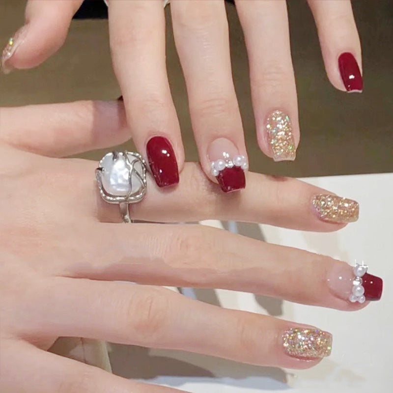 Glamorous artificial nails with glitter and pearl decorations Stornfield