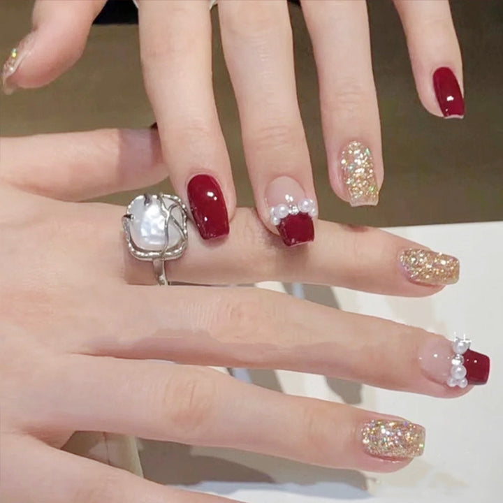 Glamorous artificial nails with glitter and pearl decorations Stornfield