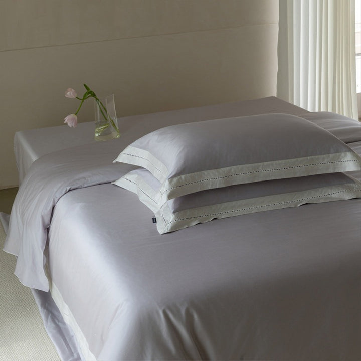 Fine cotton satin bedding set with contrasting linen border and decorative stitch trim