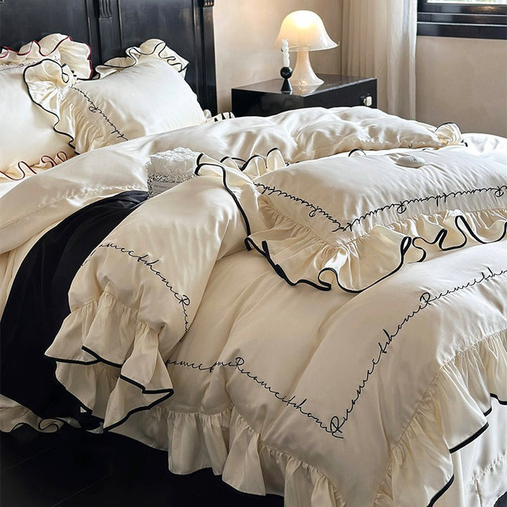 Luxurious cotton satin bedding set with ruffled flounces, contrasting piping & calligraphic embroidery