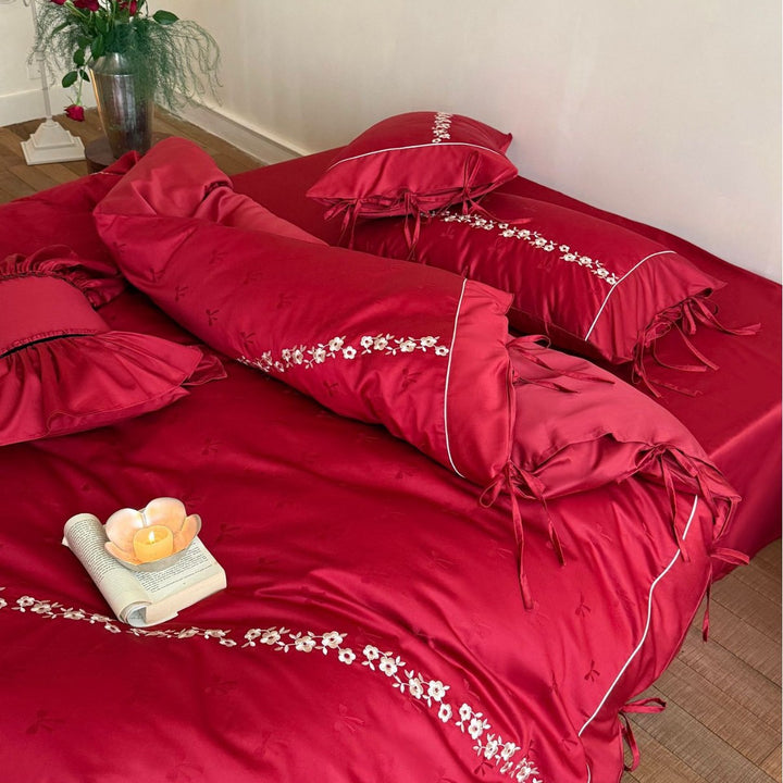 Bedding set made of cotton satin with floral border embroidery, decorative bows and pillow ensemble