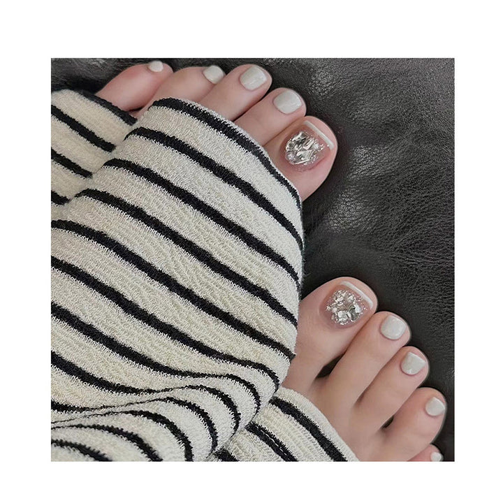 Artistic toenail art with rhinestone and glitter elements Stornfield
