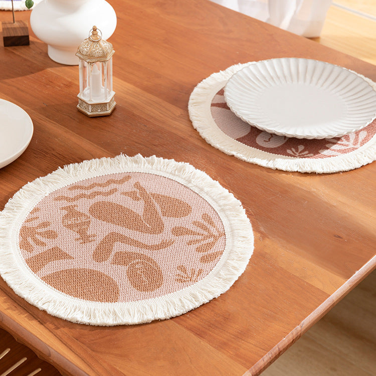 Round woven placemat with fringes and abstract figure motif Stornfield
