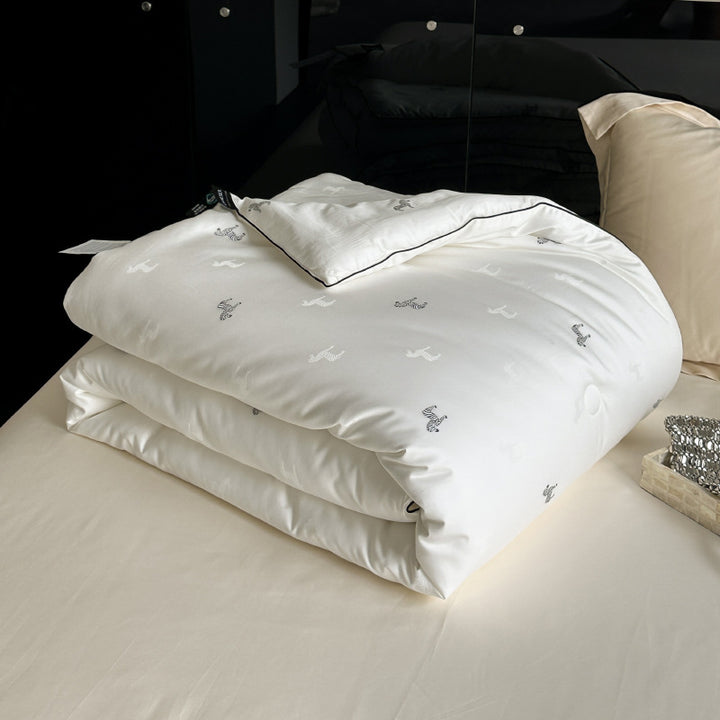 Light-warming cassette comforter with hollow fiber filling and fine tonal embroidery