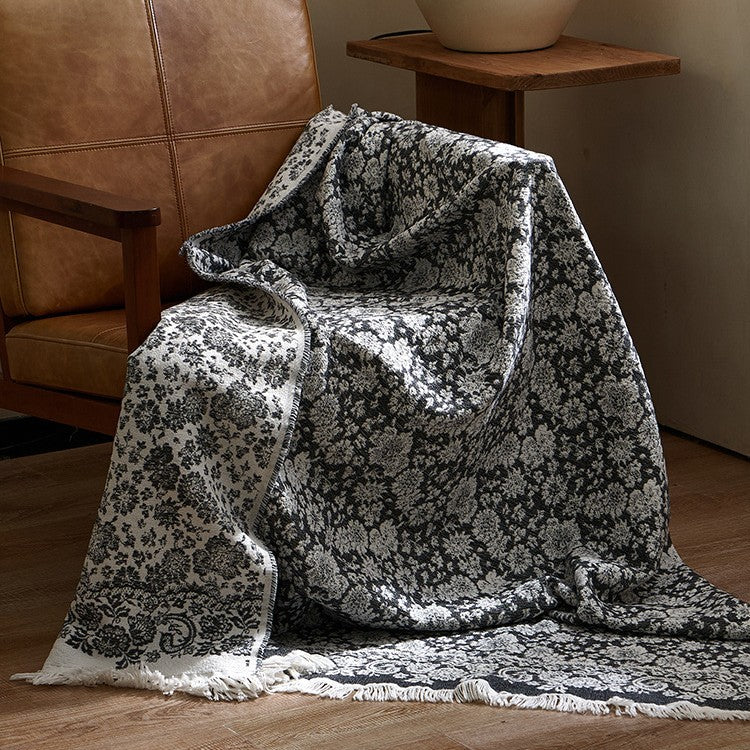 Large cozy living blanket made of cotton blend fabric with geometric jacquard pattern and fringed hem