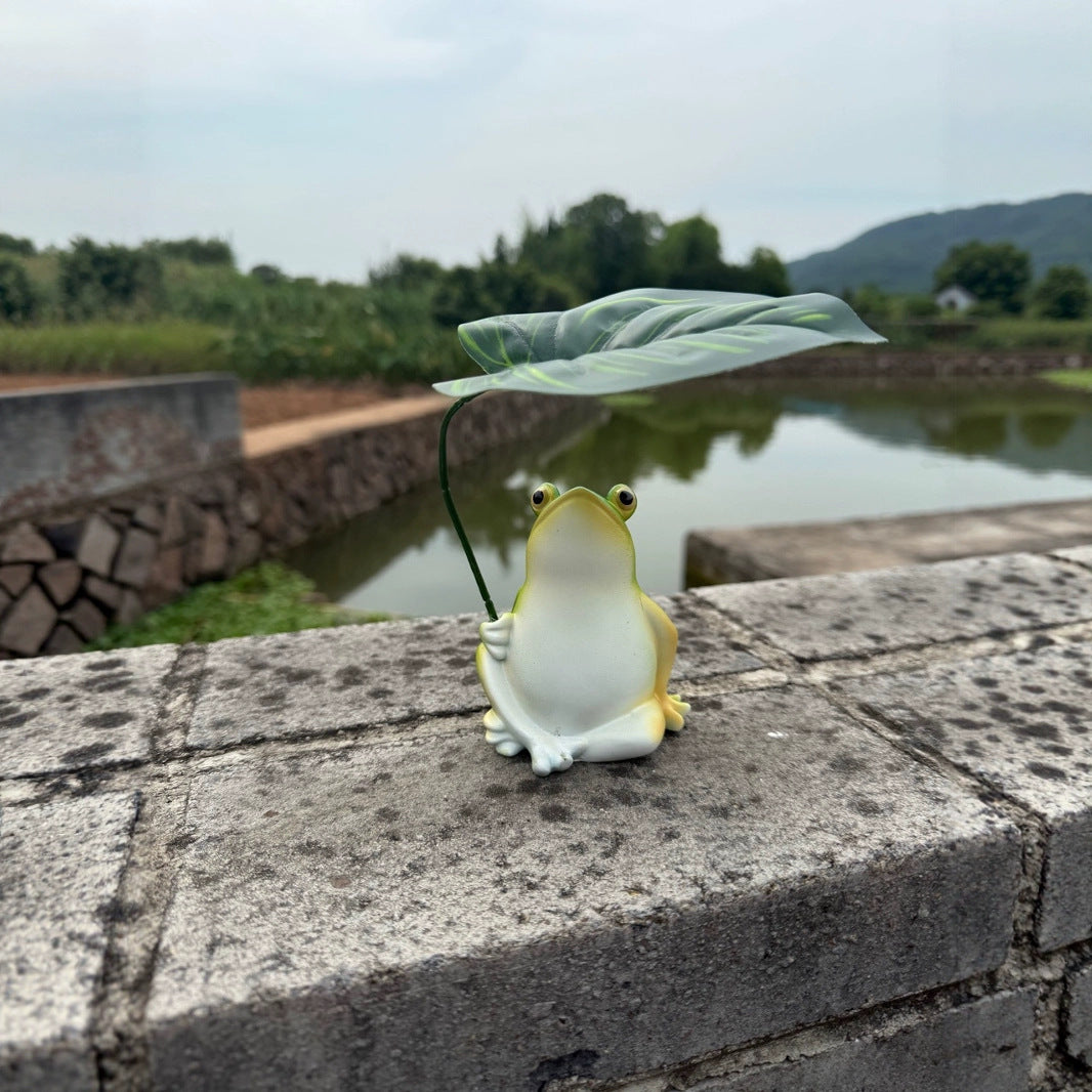 Playful frog decorative figure with leaf Stornfield